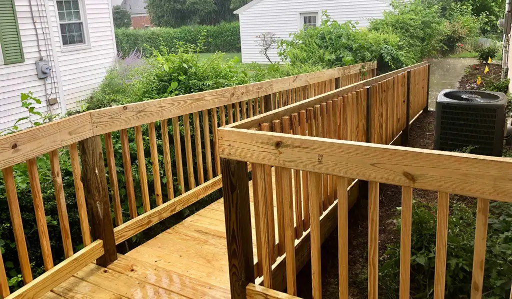 Wooden accessibility ramp beside a house.